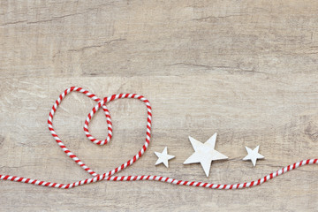 Fototapeta na wymiar heart from red white ribbon and star on wood