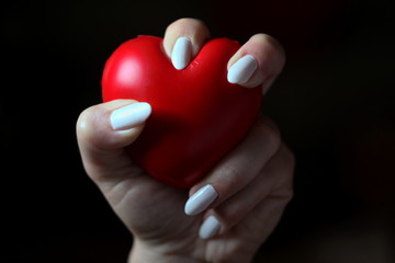 Female hand holding a red hearth