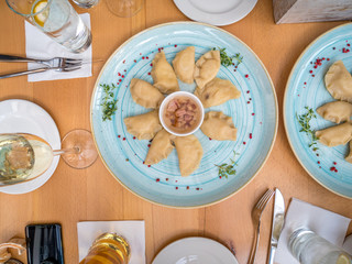 Pierogi, Polish Dumplings with pork on blue plate. Top view.