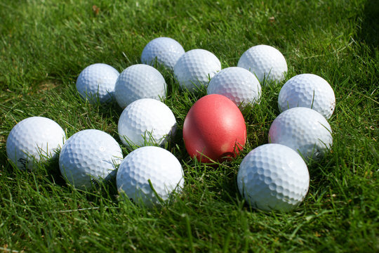 Integration-rotes Ei von Golfb&auml;llen umgeben