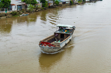 Obraz premium Wooden cargo boat on the Mekong River Delta