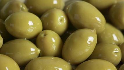 Large shiny green olives macro background
