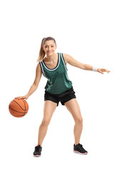 Fototapeta premium Full length portrait of a young woman playing basketball