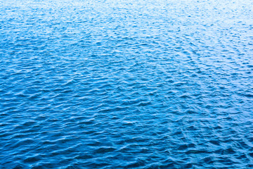 Sea ripples. Bright blue background. Shallow waves on the water.
