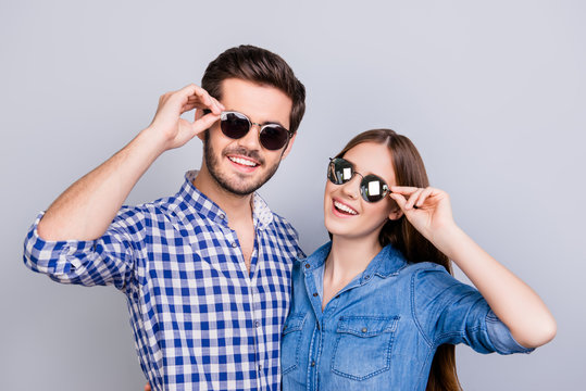Summer and fun mood. Young students are wearing trendy sunglasses and smile, in casual shirts, posing on the pure background