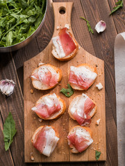 Appetizing baguette with bacon , greens