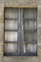 Old window in wooden frame with curtains