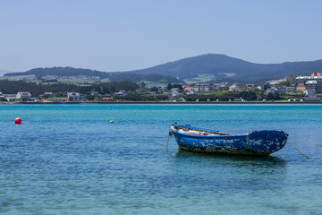 An old blue boat moored in the bay