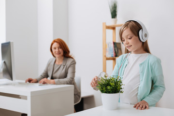 Kind admirable child watering a flower