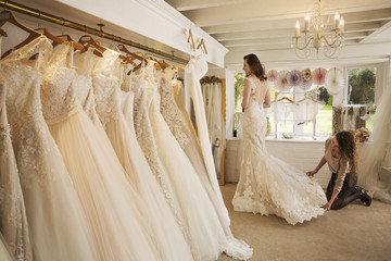 Rows of wedding dresses on display in  specialist wedding dress shop