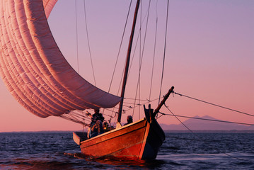霞ヶ浦の帆曵き船の白い帆が夕日に染まる