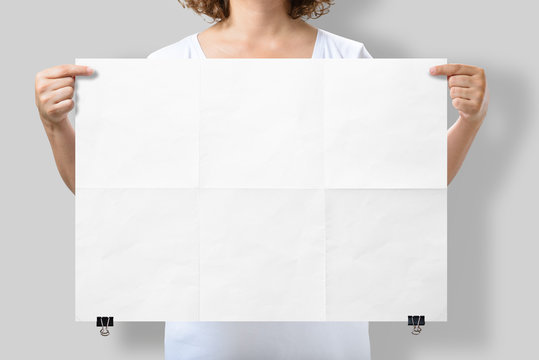 Woman Holding A Blank A2 Poster Mockup Isolated On A Gray Background. 