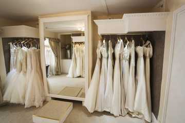 Rows of wedding dresses on display in a specialist wedding dress shop. Bridal boutique. 