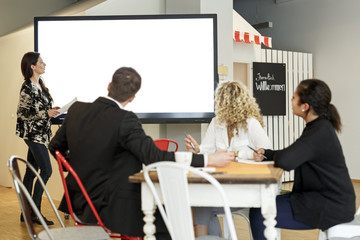 Woman leading presentation in office at large screen