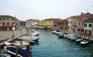 Channel with boats on the island of Murano near Venice, overcast