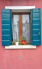 Fototapeta na wymiar Flowers on the window of a house on the island of Burano near Venice