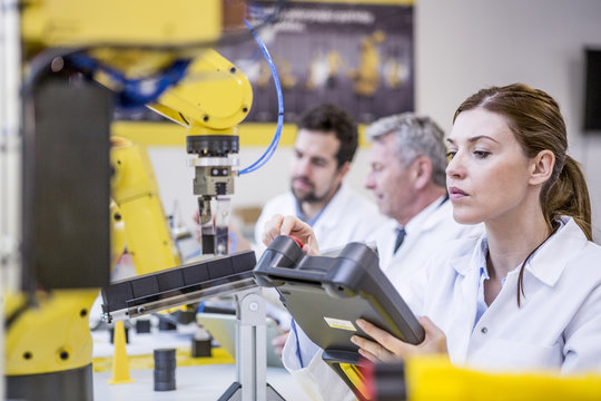 Engineers examining industrial robots