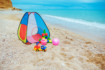 Children's tent and children's toys on the beach