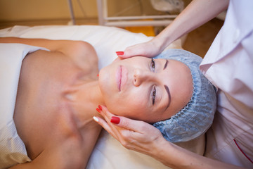 Obraz na płótnie Canvas Cosmetology doctor makes woman treatments facial massage
