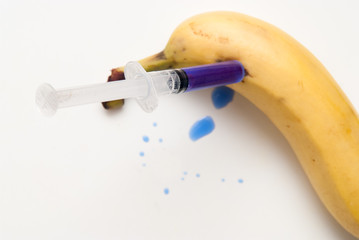 Gm food concept, additives and chemicals being injected into fruit