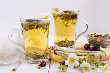 Tea of useful herbs and flowers. Two glass cups. Tea ingredients