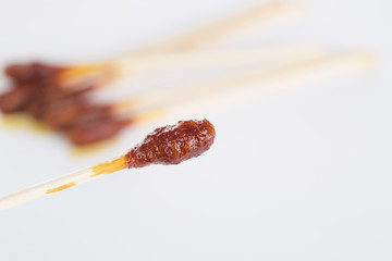 Cotton swab with iodine and glass bowl of iodine closeup on the white background.