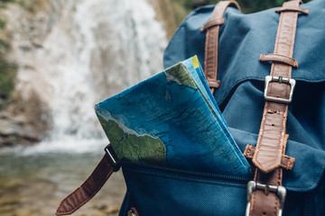 Hipster Blue Backpack, And Map Closeup. View From Front Tourist Traveler Bag On Waterfall...