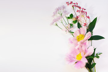 Delicate background of tree-like peony and wild flowers bouquet, top view with copy space for your text.