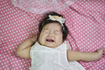 baby girl Asian, the children crying on the bed.