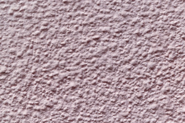 The wall is made of plaster and painted pink or beige paint.