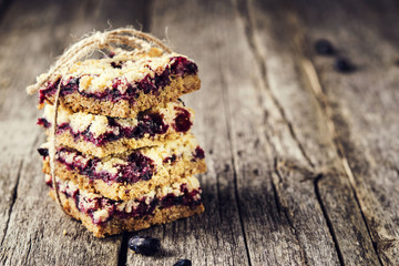 Homemade honeysuckle crumble bars, sliced crumb cake on vintage wooden table. Healthy desert. Selective focus. Toned image  