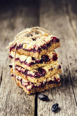 Homemade honeysuckle crumble bars, sliced crumb cake on vintage wooden table. Healthy desert. Selective focus. Toned image  