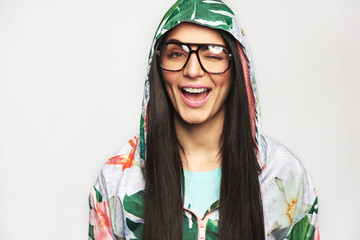 Pretty young woman in casual clothes winking at camera