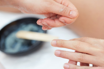 Obraz na płótnie Canvas Woman Getting a Salt Scrub Beauty Treatment on hands in the Health Spa