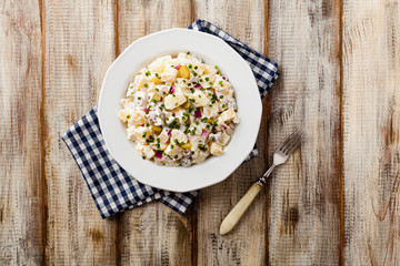 Traditional German potato salad with cucumber, onion and mayonnaise. Top view.
