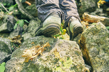 Shoes of a hiker climbing up the rocky mountain    
