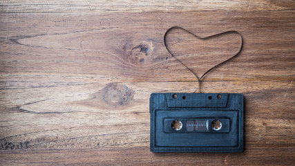 heart shape from cassette tape on vintage background, top view