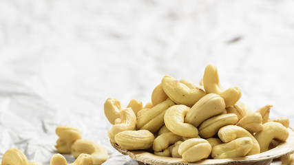 A landschape shot of cashew nut which are in a wooden bowl.