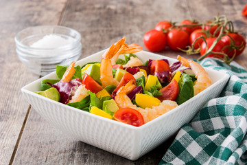 Shrimps salad with mango and avocado on wooden table
