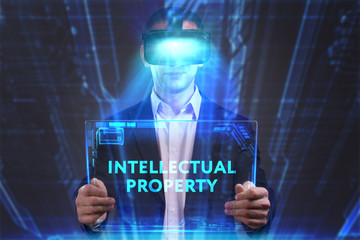 Business, Technology, Internet and network concept. Young businessman working in virtual reality glasses sees the inscription: Intellectual property