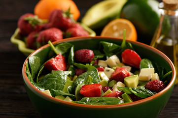 Spinach salad with strawberries, avocado and cheese.