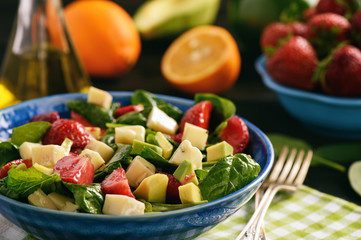 Spinach salad with strawberries, avocado and cheese.