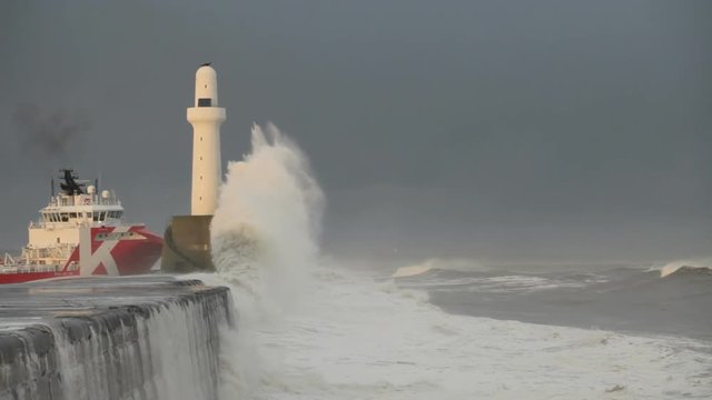 Oil support vessel leaving Aberdeen harbour, Scotland, in heavy seas