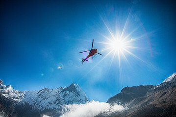 Fototapeta na wymiar Mt.Machapuchare and helicopter with the sun