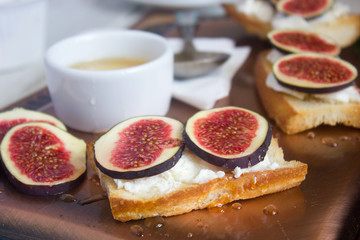 Bruschetta with goat cheese and figs on copper tray