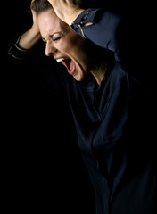 angry woman in dark dress isolated on black background