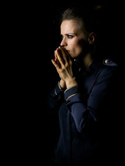 pensive woman in dark dress isolated on black background
