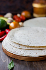 Mexican flatbread tortilla on wooden background.