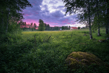 Countryside landscape at summer night with colorful sunset in Finland