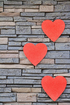 Row of red hearts on a brick wall